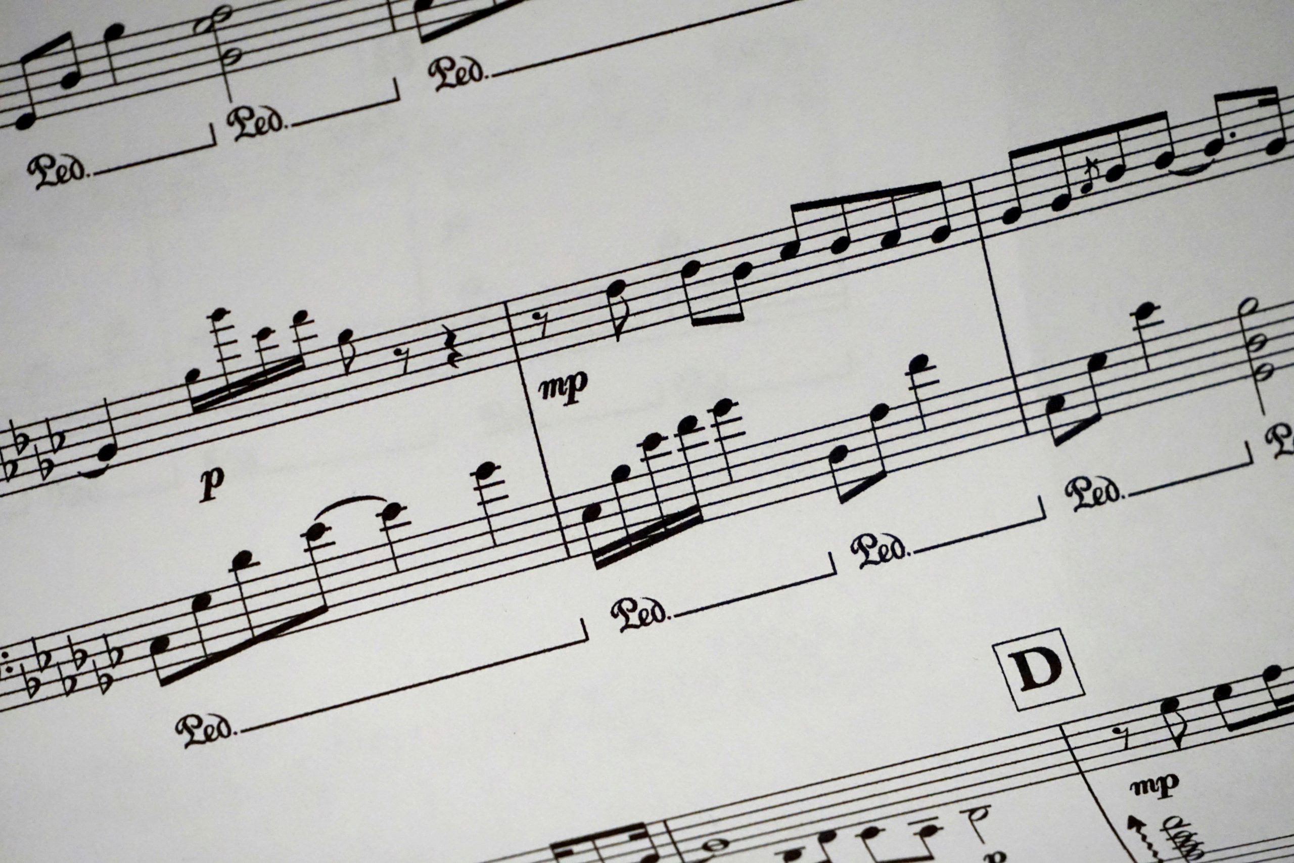 Close-up of a detailed musical sheet showcasing notes and symbols in black and white.